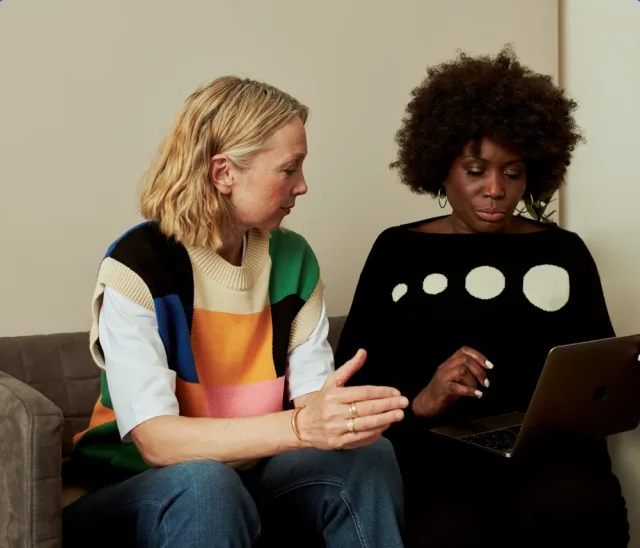 Two Cashew Collective panelists reviewing a study together on a laptop