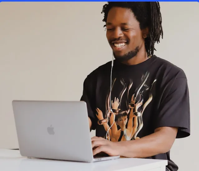 A Cashew Collective panelist smiling while completing a study on a laptop